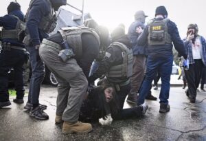 ICE agents detain a woman after pulling her from a car Tuesday in Minneapolis.